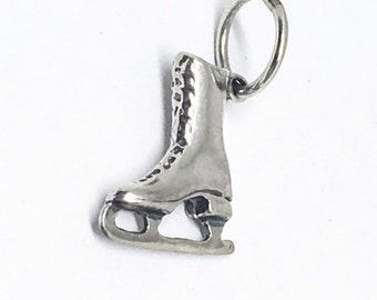 Peut inclure: Breloque en argent en forme de patins à glace. Le breloque a une boucle en haut pour l'attacher à un bracelet ou un collier.