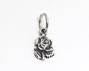 May include: A silver charm in the shape of a rose with leaves. The rose is detailed and has a classic design.