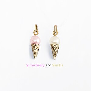May include: Two gold ice cream cone charms, one with a pink pearl and the other with a white pearl. "Strawberry and Vanilla" is written below the charms.