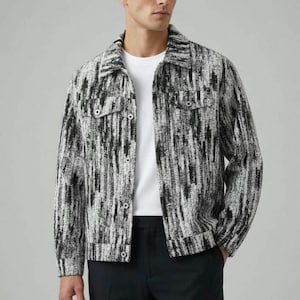 May include: A black and white patterned jacket with a collared neckline and buttoned front. The jacket is worn over a white t-shirt and paired with black pants. The overall style is modern and casual.