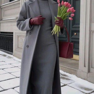 May include: A person in a grey wool coat, dress, and hat, holding a bouquet of pink tulips and a burgundy handbag. The outfit includes burgundy gloves and shoes. The setting is a snowy, urban environment.