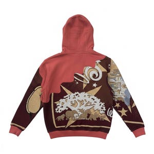 May include: A rust-colored hoodie with a detailed tapestry design on the back. The design includes a tree, elephants, stars, and swirling shapes in shades of brown, beige, and white. The hoodie has a hood and ribbed cuffs.