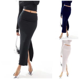 May include: Three long skirts with a side slit. The skirts are black, navy blue, and white. The skirts are made of a stretchy material and are fitted to the body.