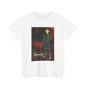 Puede incluir: Camiseta blanca con un gráfico de un personaje de anime frente a un coche deportivo rojo. El gráfico incluye el texto "Send it" en un cuadro blanco. El personaje lleva una chaqueta verde, vaqueros azules y zapatillas blancas y negras.