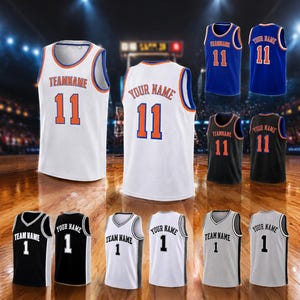 May include: A collection of sleeveless basketball jerseys in white, blue, and black. Each jersey features the text TEAMNAME or YOUR NAME and a player number, either 11 or 1, printed in a bold font on the front and back of the garments.