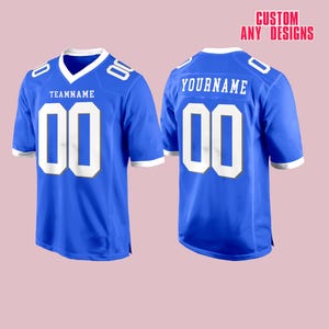 May include: A royal blue football jersey with white accents and the number "00" on the front and back. The front of the jersey has the text "TEAMNAME" above the number, and the back has "YOURNAME". The text "CUSTOM ANY DESIGNS" is at the top.