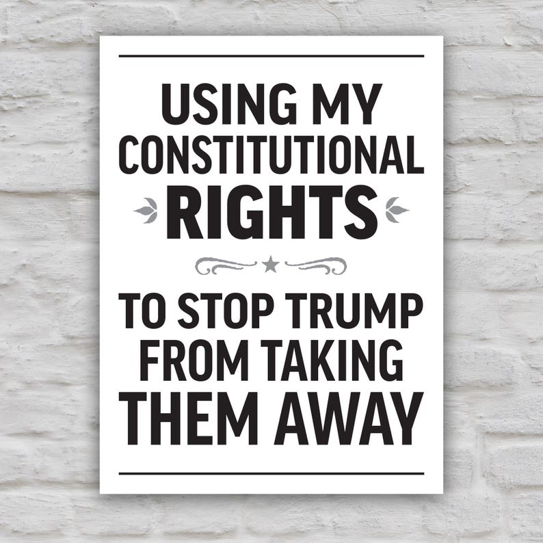 Black and white version of protest sign with bold uppercase text that reads "Using my constitutional rights to stop Trump from taking them away."