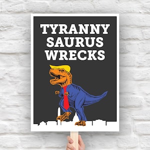 以下が含まれることがあります： 「TYRANNY SAURUS WRECKS」の文字と、スーツ、ネクタイ、金髪のかつらをつけた漫画の恐竜が描かれたポスター。 恐竜はオレンジと青で、下部に都市景観のシルエットがあります。