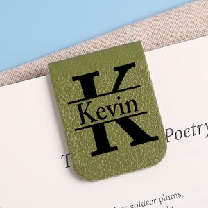 May include: A rectangular olive green magnetic bookmark with rounded bottom corners. The surface features a textured finish and is printed with a large black letter K, with the name Kevin centered horizontally across the letter in black text.