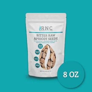May include: A white packet of Bitter Raw Apricot Seeds, 227 g. The packet features the text "RNC" and details about the product, including "All Natural," "California Grown," and "Gluten Free." The packet contains apricot seeds.