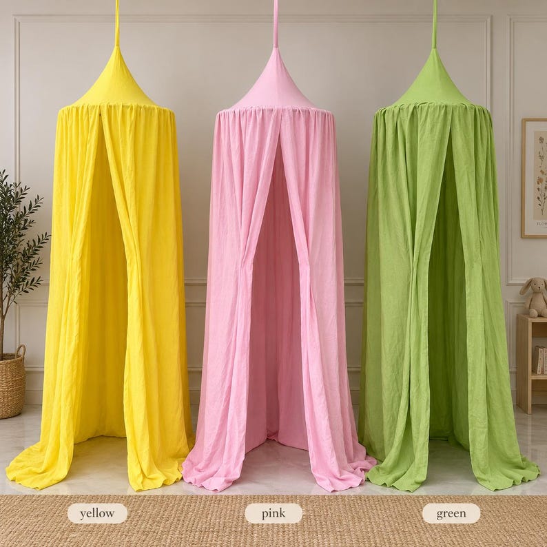 May include: Three hanging fabric canopies in bright yellow, soft pink, and light green. Each canopy features a conical top section that gathers into a central point for suspension, with long, flowing fabric panels that drape down to the floor.