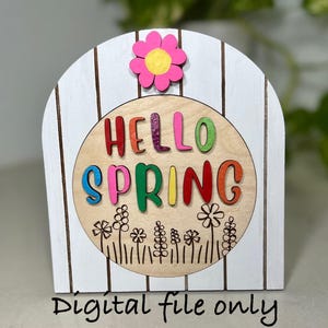 May include: Wooden spring-themed sign with a white arched background and brown vertical stripes. A pink and yellow flower is at the top. The sign features the words "HELLO SPRING" in colourful letters and a floral design. Text at the bottom reads "Digital file only".