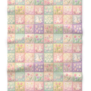 May include: A pastel-colored Easter-themed blanket with a patchwork design. Each square features illustrations of bunnies, Easter eggs, flowers, and tulips in soft shades of pink, yellow, green, and purple. The blanket is made of a soft, quilted material.