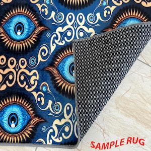 May include: A blue rug featuring a repeating pattern of large, stylized blue eyes with gold and brown accents. The rug's design includes decorative swirls and the text "SAMPLE RUG" in red.