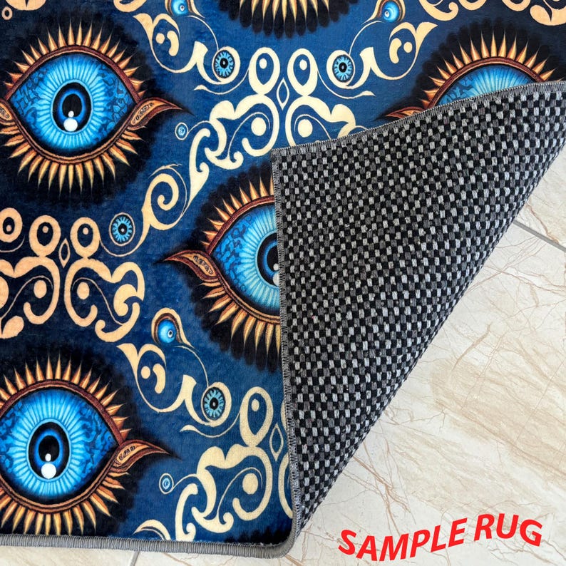 May include: A blue rug featuring a repeating pattern of large, stylized blue eyes with gold and brown accents. The rug's design includes decorative swirls and the text "SAMPLE RUG" in red.