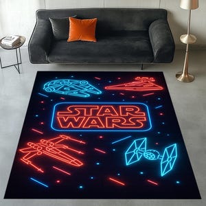 May include: Black rectangular Star Wars rug with neon-style illustrations of the Millennium Falcon, X-wing, TIE fighter, and Star Destroyer. The words "STAR WARS" are in a neon font. The rug is on a grey floor.