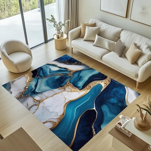 May include: Abstract area rug with a blue and white marble design with gold accents. The rug has a modern and contemporary style.