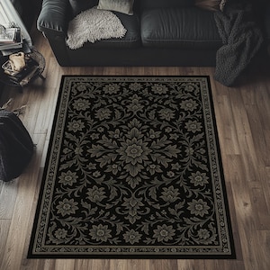 May include: A rectangular black area rug with a floral pattern in shades of gray and beige. The rug features a central medallion design surrounded by stylized flowers and foliage. A decorative border frames the rug's edges, adding a touch of elegance.