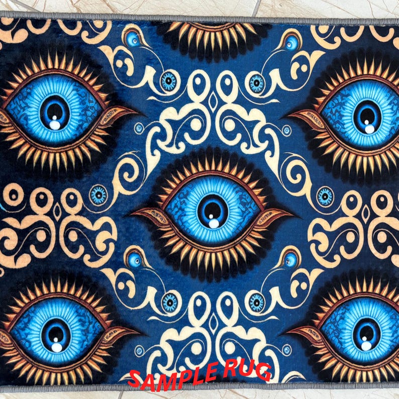 May include: A blue rug with a repeating pattern of large, stylized blue eyes with gold and black accents. The rug has a dark blue background with cream-colored scrollwork. The text "SAMPLE RUG" is printed in red at the bottom.