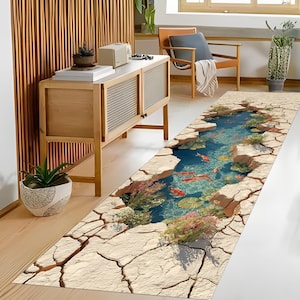 Puede incluir: Una alfombra larga y rectangular con un diseño de estanque en 3D. La alfombra presenta un borde de tierra agrietada que rodea un estanque azul vibrante con peces koi, nenúfares y plantas acuáticas. La alfombra está diseñada para uso en interiores.