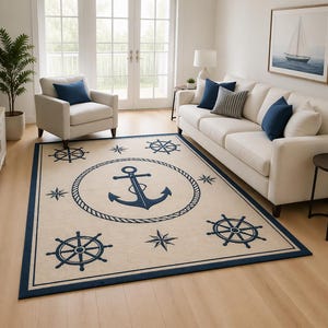 May include: A rectangular nautical-themed rug with a cream background and a navy blue border. The rug features a large anchor design in the center, surrounded by a rope circle, along with ship wheels and stars.