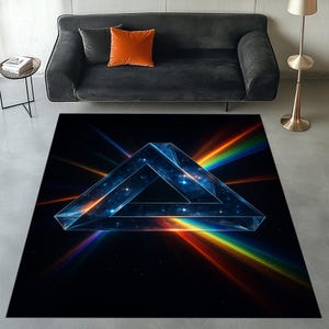 May include: A large, rectangular area rug with a black background and a geometric, blue, three-dimensional triangle design. The triangle is surrounded by colorful rainbow light beams. The rug is placed in a living room setting.
