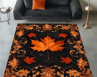 May include: A rectangular rug with a large orange maple leaf design, surrounded by smaller red leaves and gold leaf patterns on a black backdrop. The rug is placed on a grey floor.