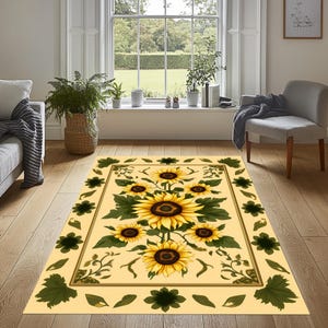 May include: A rectangular area rug with a sunflower design. The rug features a cream-colored background with a border of green leaves and dark green flower shapes. The center showcases large yellow sunflowers with brown centers and green leaves.