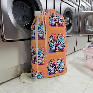 May include: A colorful laundry bag with a drawstring closure. The bag features a repeating pattern of pixelated cartoon birds with bright blue, red, yellow, and green colors on an orange background.