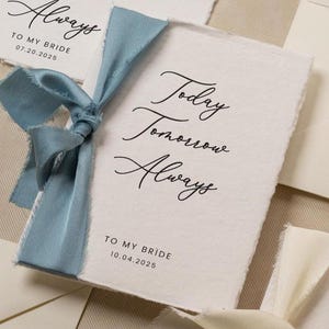 May include: Wedding stationery set featuring cards with the text "Today Tomorrow Always" tied with ribbons. The cards are accompanied by envelopes, a ring box, and a white flower. The cards are addressed "To My Bride" and "To My Groom" with dates.