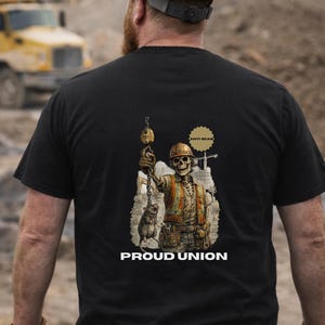 May include: Black t-shirt with a graphic of a skeleton construction worker holding a pulley and a rat. The text "PROUD UNION" is below the graphic. The shirt also has the text "ANTI-SCAB".