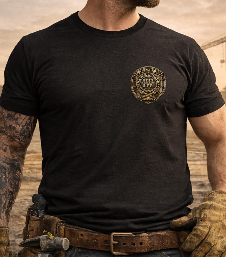 Pu&ograve; includere: T-shirt nero girocollo con un emblema dorato e marrone degli Iron Workers sul petto. L'emblema presenta il testo "Iron Workers" e attrezzi incrociati. La maglietta &egrave; realizzata in un tessuto scuro e strutturato.