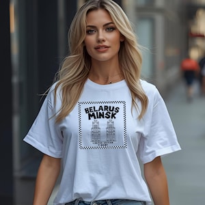 May include: White t-shirt featuring a black and white graphic of two buildings with the text "BELARUS MINSK" and "LIMITED EDITION T-SHIRT". The design is framed with a checkered border.
