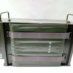Peut inclure: Bo&icirc;te m&eacute;tallique vert olive de style militaire avec deux poign&eacute;es sur le dessus. La bo&icirc;te a une forme rectangulaire avec un insert en tissu vert fix&eacute; par deux sangles grises. Le texte "RF 10-K 30" est visible.