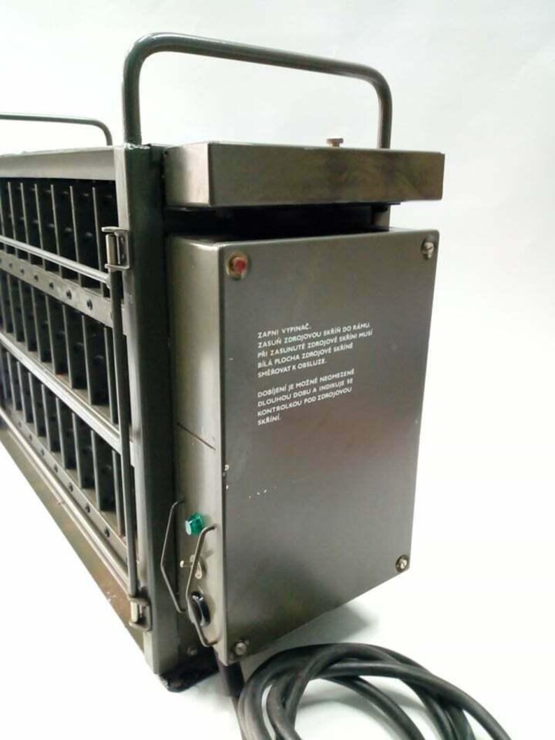 Peut inclure: Appareil industriel en m&eacute;tal vert olive avec une poign&eacute;e. Il comporte des fentes verticales, un panneau de commande avec un voyant rouge et un cordon d'alimentation. L'appareil a une poign&eacute;e sur le dessus et du texte sur le c&ocirc;t&eacute;.