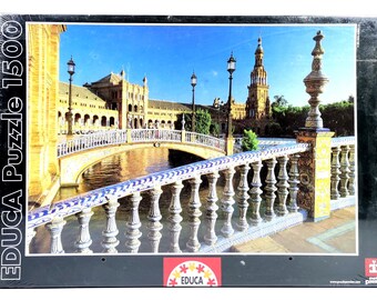 Könnte beinhalten: Ein 1500-teiliges Puzzle mit einer malerischen Ansicht einer Brücke und Gebäuden mit einem Turm unter einem klaren blauen Himmel. Die Puzzle-Box trägt den Text "EDUCA Puzzle 1500".
