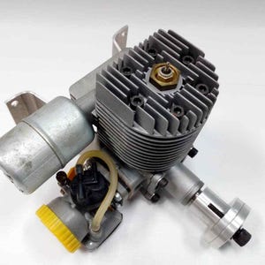 May include: A silver model engine featuring a ribbed cylinder head and a yellow fuel cap. The engine incorporates a carburetor, exhaust, and a propeller shaft. This engine is designed for model aircraft or other small-scale applications.