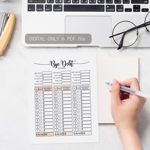 May include: A printable debt tracker with the text "Bye Debt" in a handwritten font. The tracker includes fields for debt name, total owed, monthly payments, and a payment schedule. A hand holds a pen, ready to fill out the form. The text "DIGITAL ONLY in PDF file" is also visible.