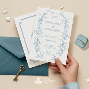 May include: A white wedding invitation with blue floral illustrations and the text "Together with their families, Olivia Mitchell & Thomas Scott,  Warmly invite you to their wedding celebration, May 10th, 2020, Villa Borghese, Via della Margherita, 12, 00198, Rome, Italy, Reception to follow".