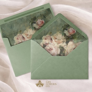 Puede incluir: Dos sobres verde salvia con ilustraciones florales. Los sobres est&aacute;n abiertos, revelando una pintura de acuarela de rosas rosas y blancas. El logotipo de The Lily Letters Co. est&aacute; en la parte inferior. El fondo es una tela suave blanquecina.
