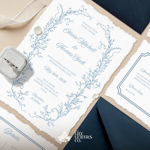 May include: Wedding invitation suite with a blue floral design. The invitation features the names Olivia Mitchell and Thomas Scott, the wedding date May 16th, 2026, and the location Villa Amore, Via della Serenita, 123, Firenze, Toscana, Italy. The RSVP details are included on the back of the invitation.