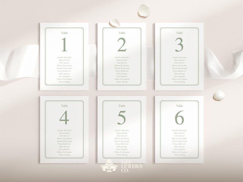 May include: Six white table number cards with sage green text and borders. Each card is labelled with a number from one to six, and includes a list of names. The cards are arranged on a light pink background with a white ribbon and decorative elements.