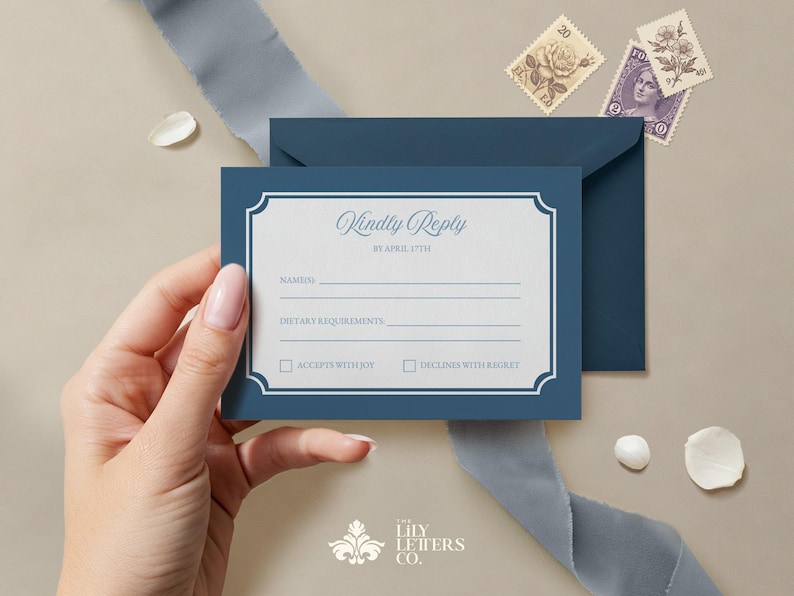 May include: A blue RSVP card with a white border and a decorative frame. The text on the card reads "Kindly Reply by April 17th". There are lines for the guest's name, dietary requirements, and two checkboxes for accepting or declining the invitation.