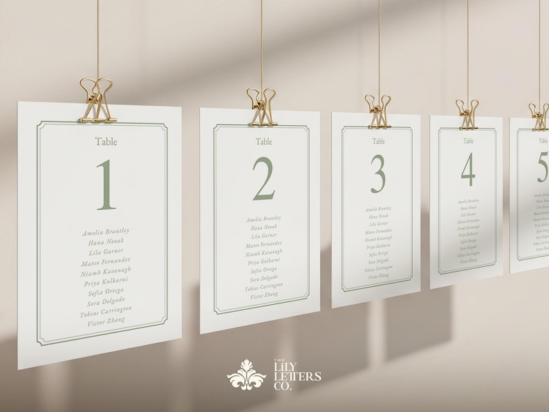 May include: Several hanging table cards numbered 1 to 5 in a soft green. Each card, held by a gold clip, displays names. The cards are for a wedding or event, with a decorative border.