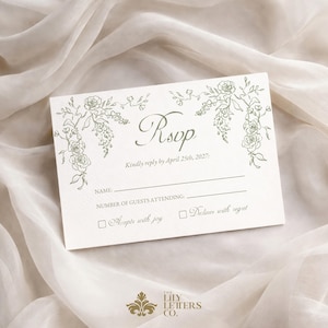 Puede incluir: Tarjeta RSVP color crema con ilustraciones florales y el texto "RSVP". La tarjeta incluye l&iacute;neas para el nombre y el n&uacute;mero de invitados, y casillas de verificaci&oacute;n para aceptar o rechazar con pesar. El logotipo de The Lily Letters Co. est&aacute; en la parte inferior.