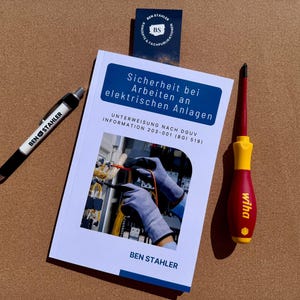 Könnte beinhalten: Ein Buch mit dem Titel "Sicherheit bei Arbeiten an elektrischen Anlagen" von Ben Stahler wird gezeigt. Ein Stift und ein Schraubendreher liegen neben dem Buch. Der Stift trägt die Aufschrift "BEN STAHLER". Der Schraubendreher ist rot und gelb.