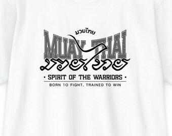 May include: White t-shirt with a Muay Thai graphic in black. The design includes the words "Muay Thai" in stylized lettering, along with text that reads "Spirit of the Warriors. Born to fight, trained to win."
