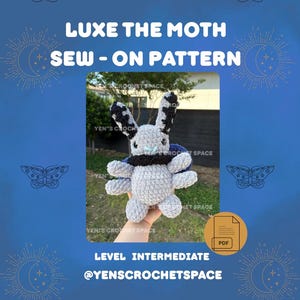 May include: A crochet pattern for "Luxe the Moth" is displayed on a blue background. The pattern is for an intermediate level project. The image shows a gray moth with black and white accents, a black collar, and blue wings. The text reads "LUXE THE MOTH SEW-ON PATTERN".