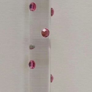 May include: A clear glass crystal ball with a silver chain attached to a silver base with a hand-shaped design. The glass tube contains pink glitter.