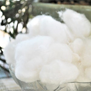 May include: A clear glass bowl filled with white cotton balls.